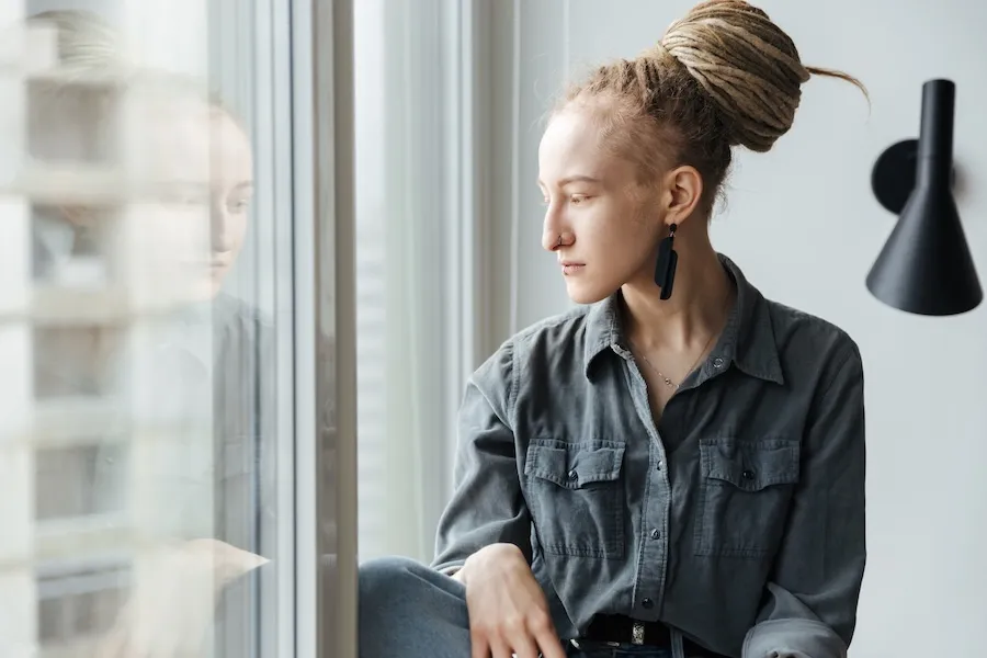 Young woman looking out the window during her therapy session.