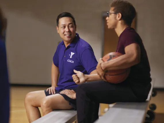 Coach laughing with a basketball player