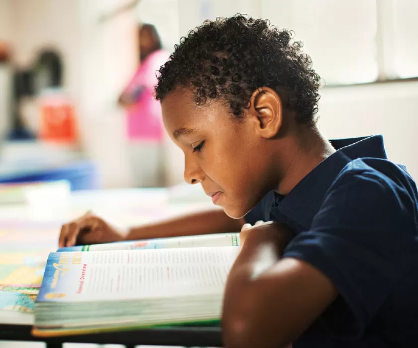 Pre-Teen reading text book in classroom